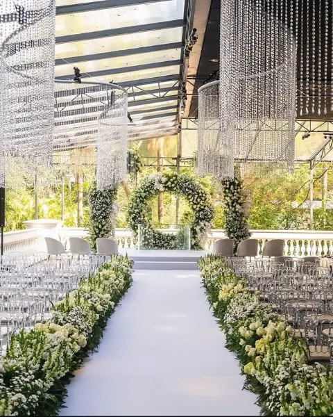 Corredor de cerimônia de casamento com flores brancas e arco de folhagens no Palácio Tangará