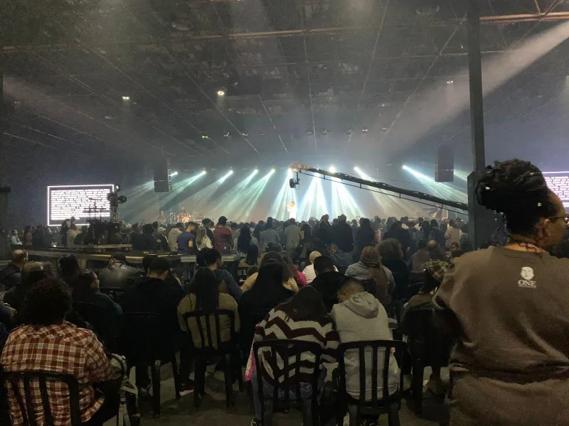 Evento da COGIC Brasil com feixes de luz sobre o palco e o público sentado