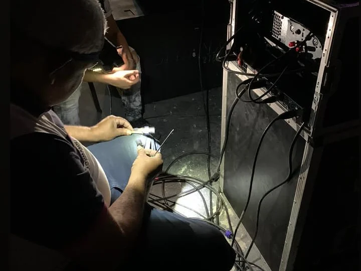 Equipe da IS preparando os cabos de um rack durante uma instalação de som
